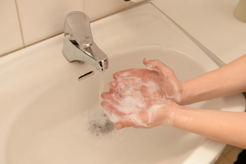 Lapsi saippuoi käsiään. A child is washing hands.