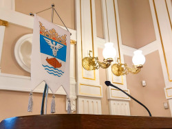 Jyväskylä-viiri ja mikrofoni puhujanpaikalla kaupungintalon juhlasalissa. Kuva Outi Kaakkuri