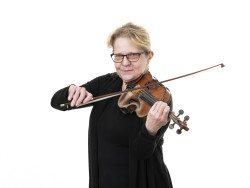 Tumma-asuinen vaaleahiuksinen nainen soittaa viulua. Kuva Jiri Halttunen